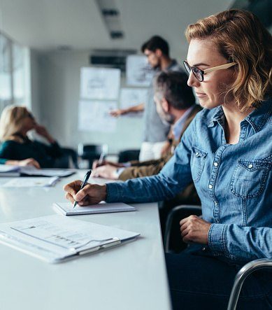 A consultation professional taking notes during a briefing session