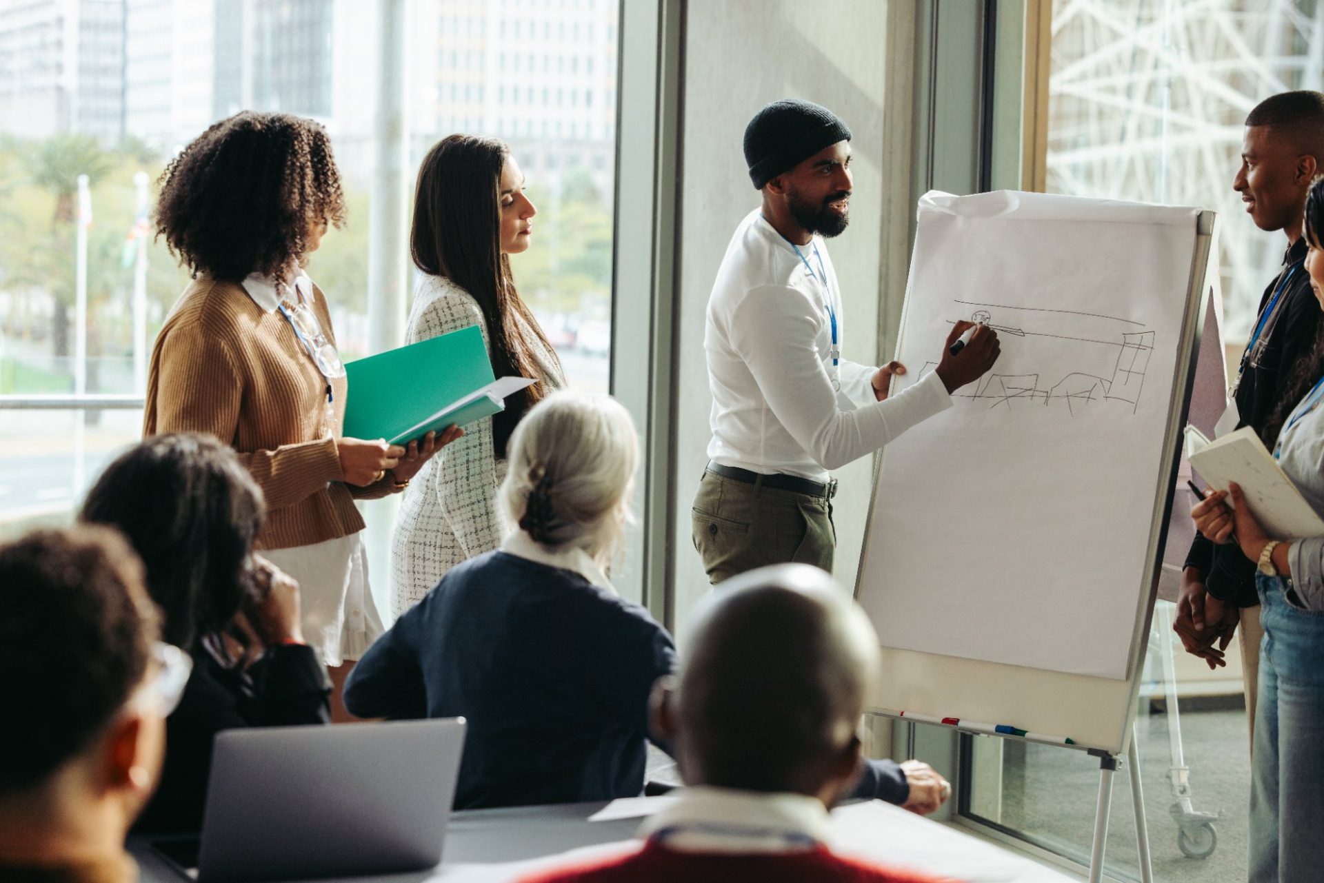 A facilitator presenting at a flip chart to an engaged group