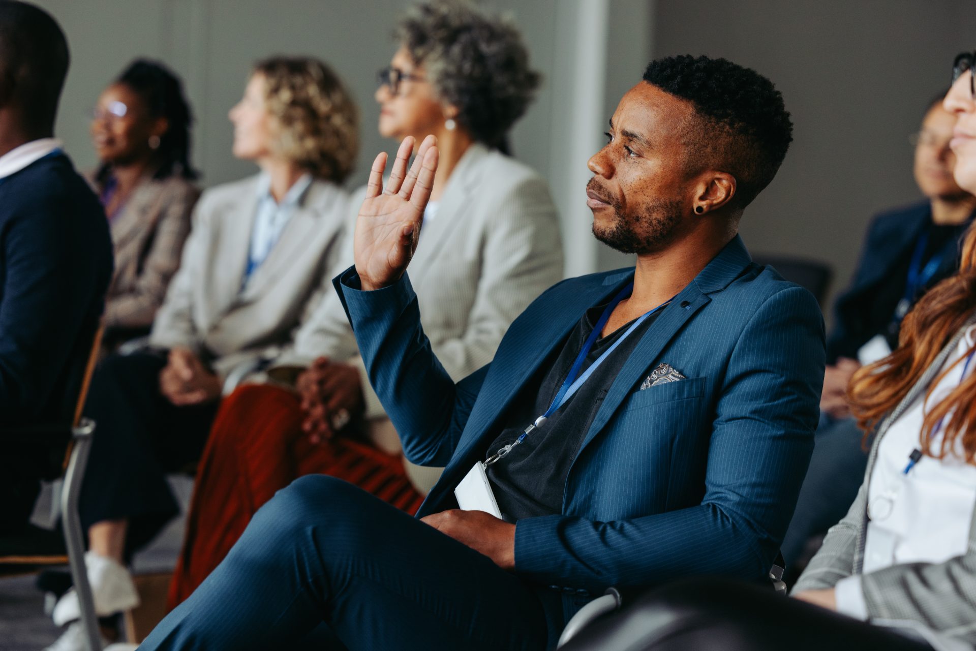 A delegate raising a hand to ask a question from the audience