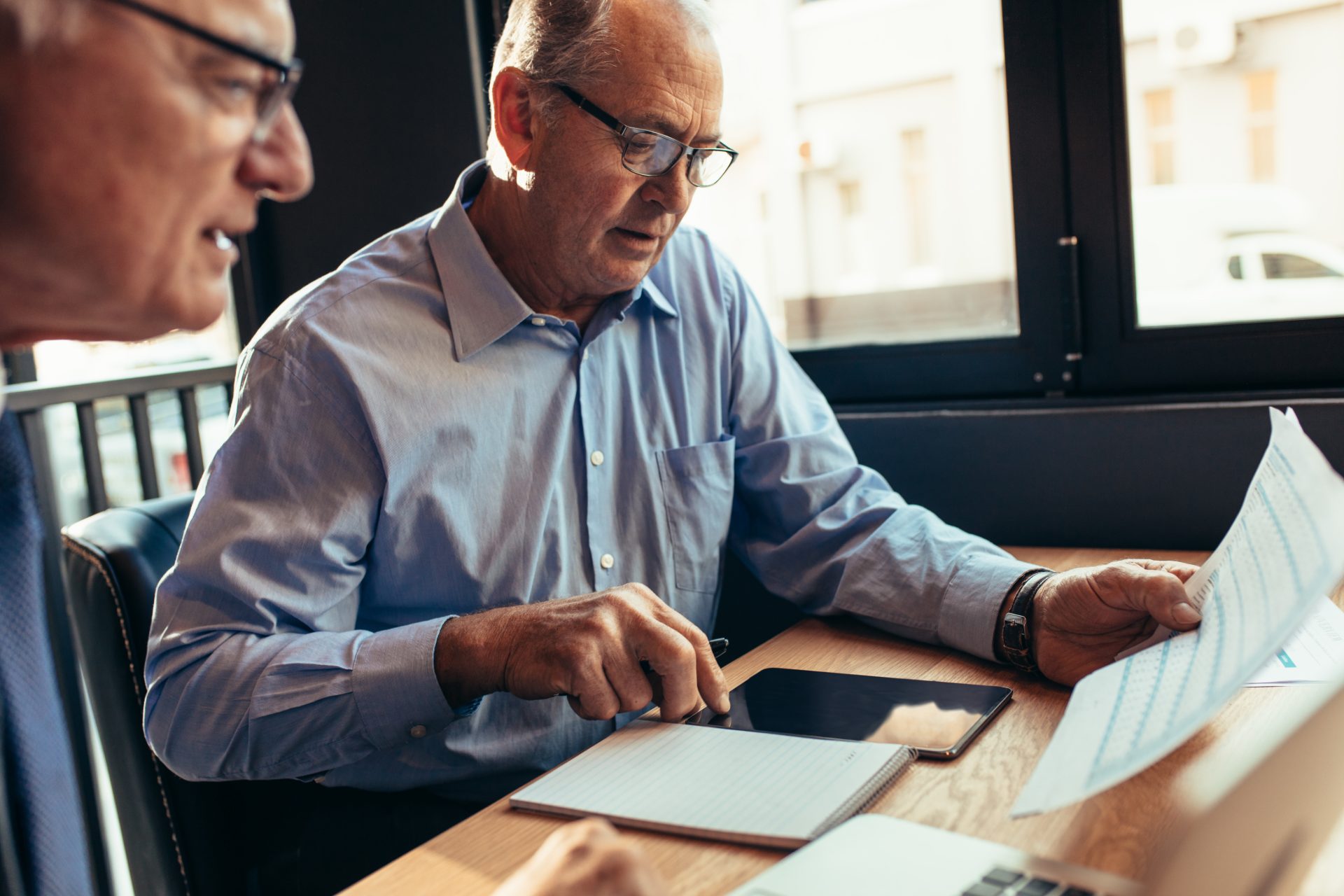 Two colleagues reviewing consultation paperwork together at a table