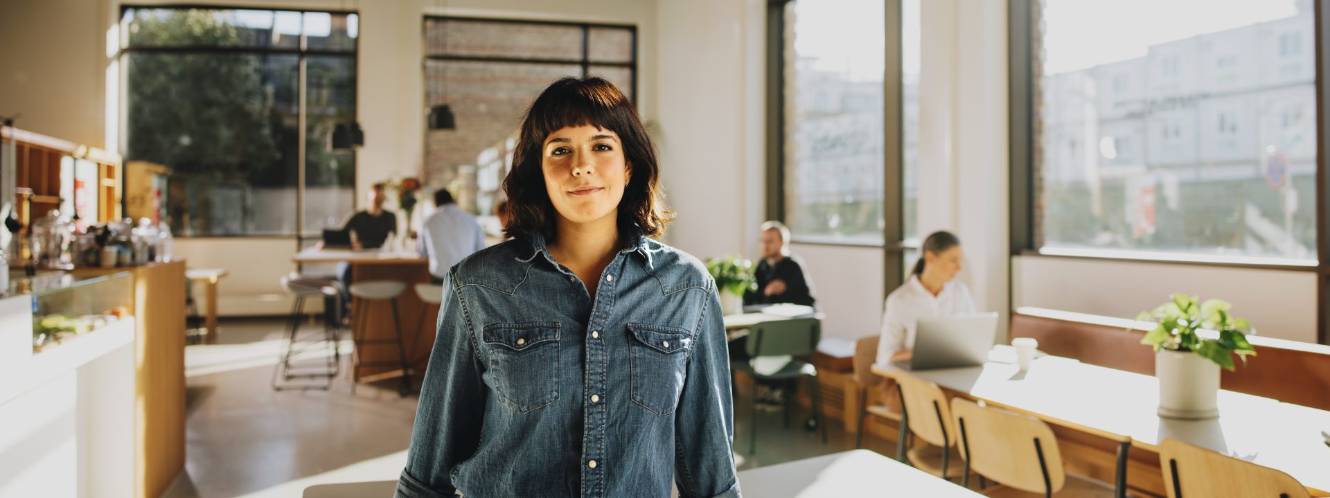 A practitioner standing in an open-plan office looking towards the camera