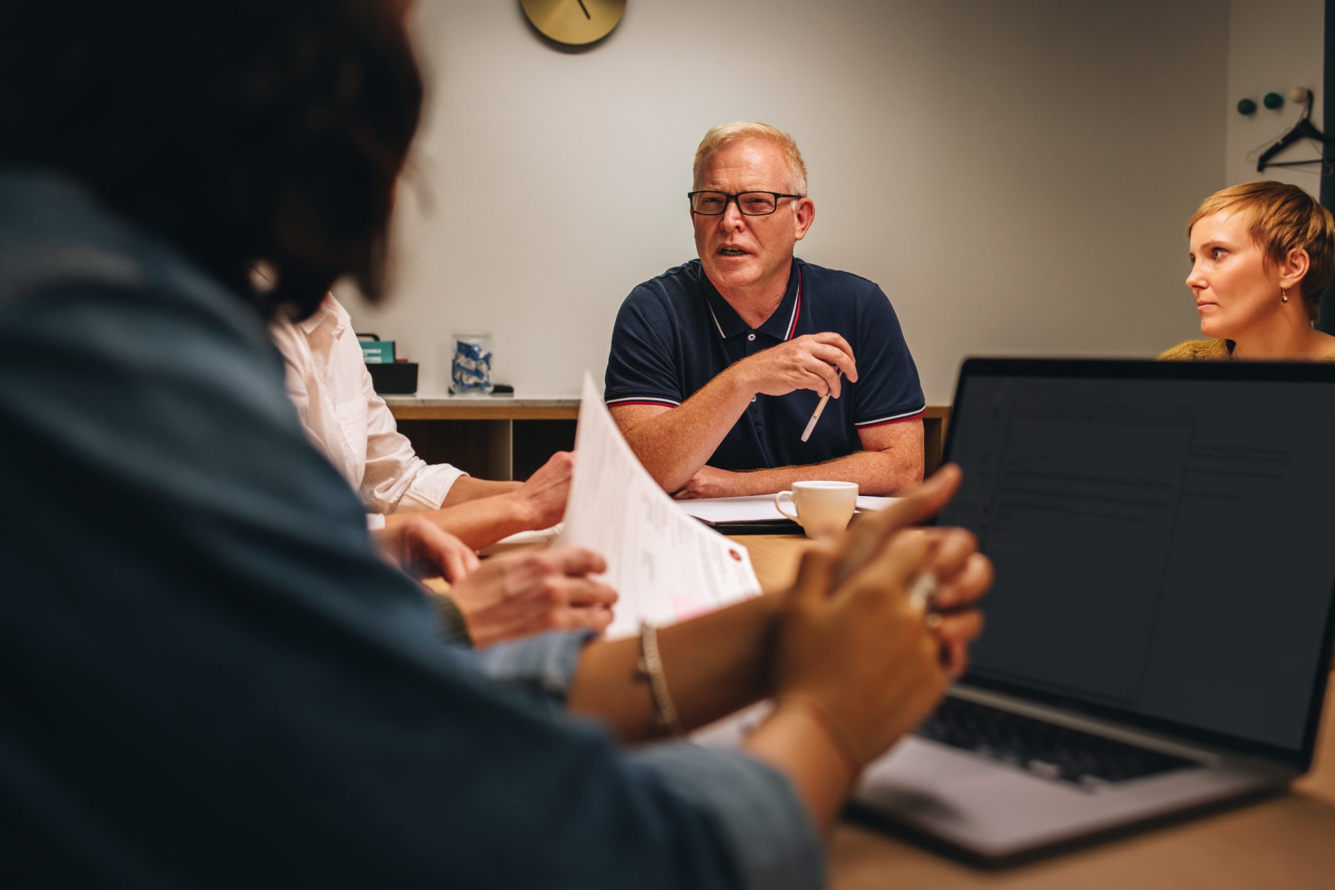 Colleagues discussing a document across a meeting table