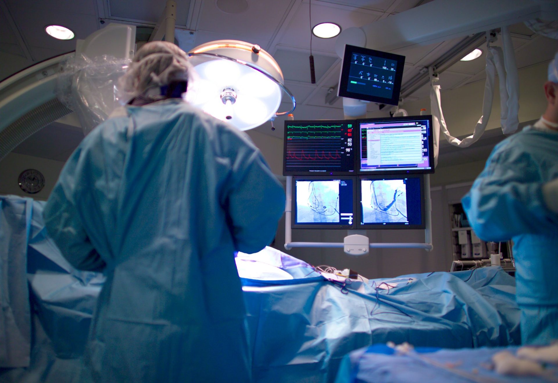 A surgical team in an operating theatre with patient monitors