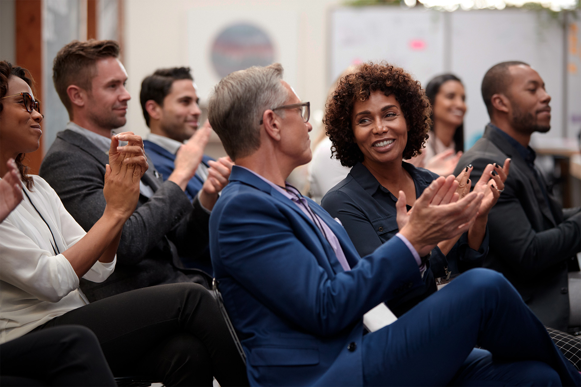 Delegates seated in rows at a conference, listening to a presentation