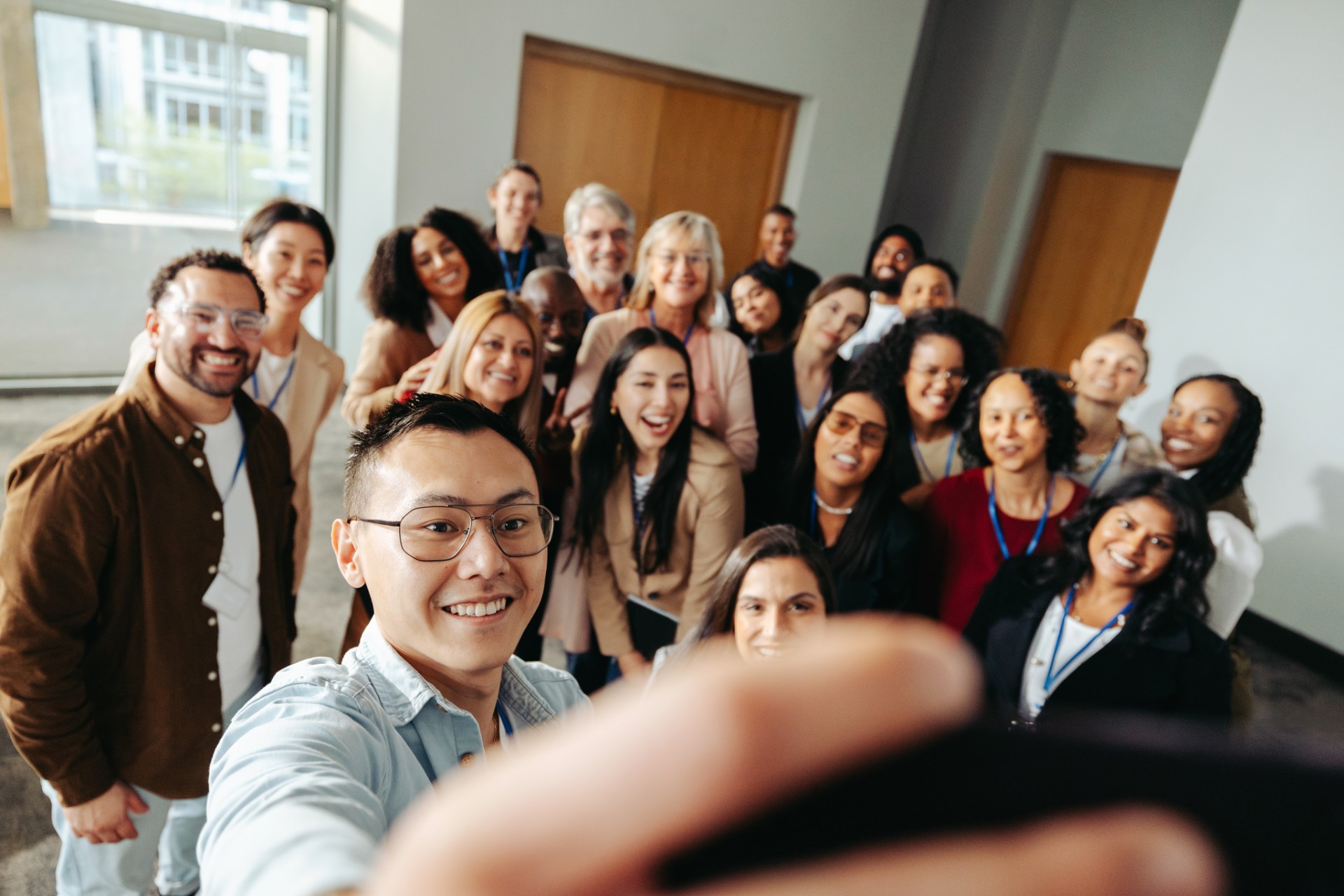 A large group of colleagues gathered together, smiling for a photograph after a session