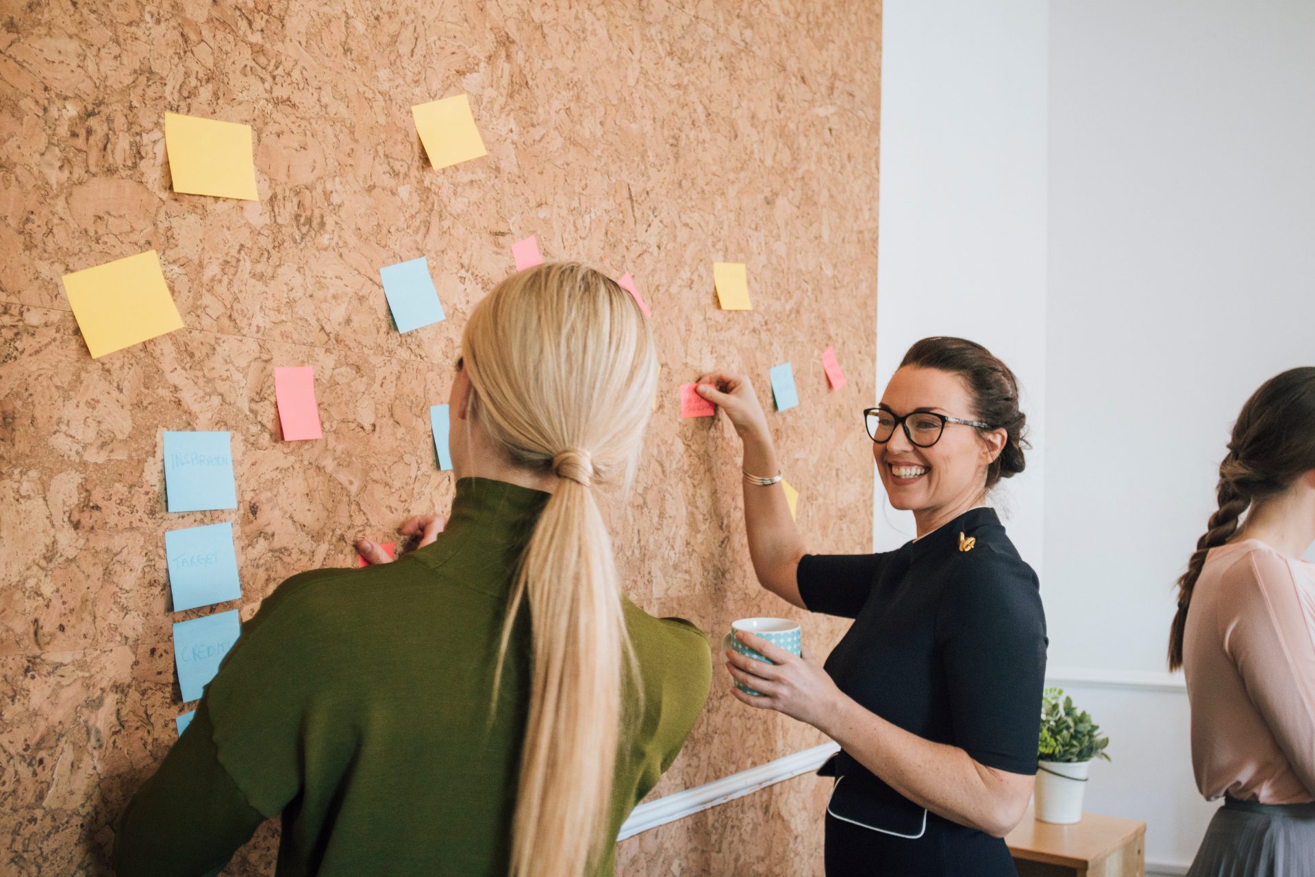 Colleagues mapping stakeholders with sticky notes on a board