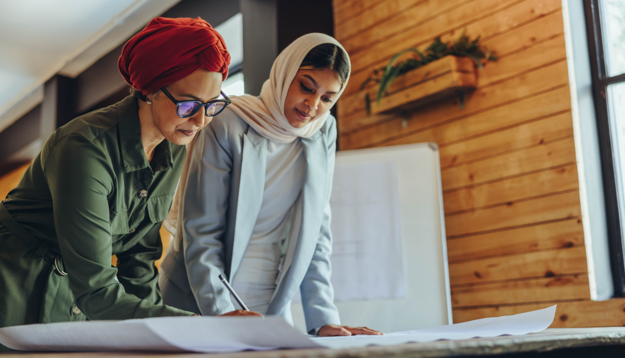 Two consultation professionals reviewing plans together at a desk
